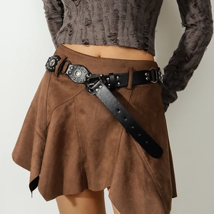Dettaglio della cintura in pelle Y2K con borchie argento su gonna in camoscio marrone
