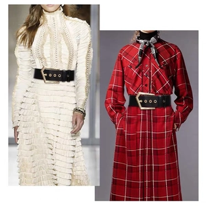 Detail of wide black PU belt with gold geometric pentagon buckle on various dresses