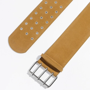 Gros plan d'une ceinture corset en daim jaune moutarde avec triple boucle argentée et œillets
