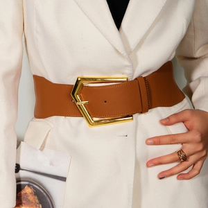 Women wide brown leather corset belt with a large geometric gold buckle on a white blazer