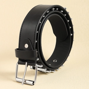 Detail of black punk leather belt with silver conical studs and metal needle buckle