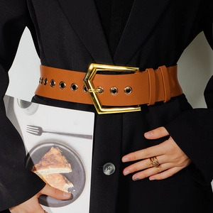 Detail of brown wide belt with golden pentagon metal buckle and eyelets on a black suit