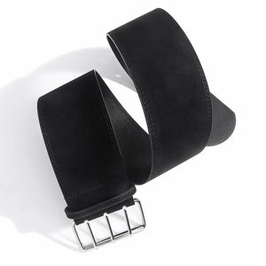 Détail d'une ceinture en daim noir mat avec boucle métallique argentée à quatre broches