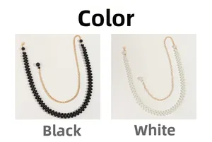 Détail de la chaîne de corps en perles et perles noires avec chaînes dorées superposées