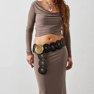 Detail of bohemian wide belt with black discs and vintage gold metal floral carvings