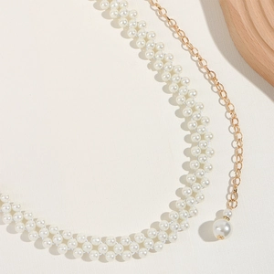 Détail de la chaîne de taille en perles multicouches avec maillons dorés et pendentif perle