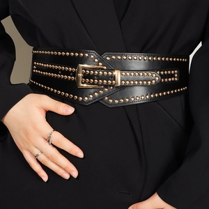 Primer plano de cinturón ancho punk para mujer con tachuelas doradas y hebilla sobre blazer