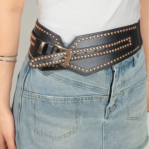 Detalle de cinturón punk negro con tres filas de remaches oro rosa y hebilla metálica