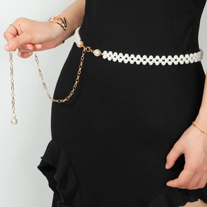 Détail de la chaîne de corps en perles blanches doubles avec fermoir doré sur robe noire
