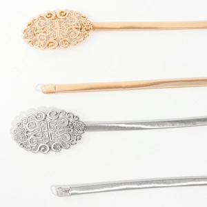 Détail de ceintures élastiques en métal doré et argenté avec boucles filigranes ornées