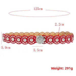 Close-up of red bohemian belt with circular hollow leather patterns and silver sun buckle