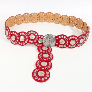 Detail of red boho belt with silver grommets and vintage carved circular buckle