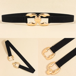 Detail of black elastic waist belt featuring a polished gold geometric metal buckle