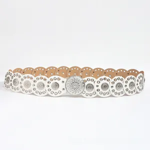 Detail of white bohemian faux leather belt with metal studs and large embossed buckle