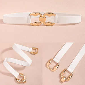 Close-up of golden interlocking buckle on white elastic waist belt for dresses