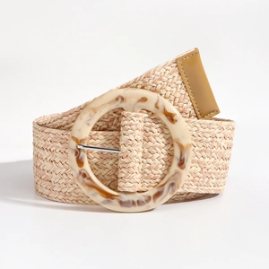 Détail d'une ceinture large en paille tressée avec boucle ronde en résine marbrée ambre