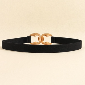 Detail of the golden zinc alloy geometric buckle on a black elastic waist belt