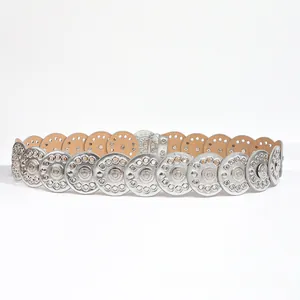 Close-up of bohemian silver hollowed-out metal disks with intricate floral engraving details