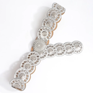 Detail of bohemian Y2K belt featuring silver sunflower embossed metal discs on white background