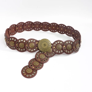 Detail of bohemian brown leather belt with layered round pieces and vintage metal buckle