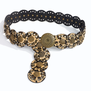 Detail of leopard print discs and vintage metal floral buckle on a bohemian belt