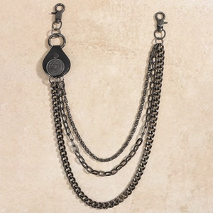 Close-up of triple-layered gunmetal punk chain with lobster clasps and round emblem