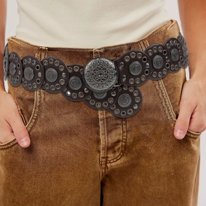 Detail of bohemian dark brown leather belt with vintage silver filigree metal discs