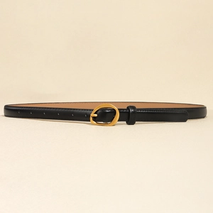 Detailed close-up of a minimalist black leather belt with a polished gold oval buckle
