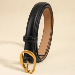 Detail of slim black belt with vintage gold oval buckle and neat stitching on smooth leather