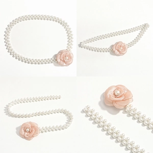 Detail view of double-row pearl waist chain featuring a soft pink camellia flower ornament