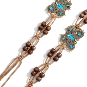 Ceinture tressée bohème avec boucle papillon vintage et perles turquoise sur fond blanc