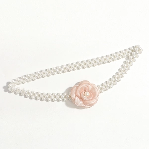 Detail of elegant double-strand pearl waist chain featuring a soft pink fabric rose accessory