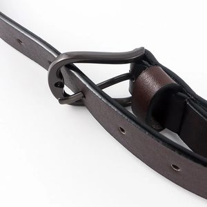 Detail of a dark brown leather belt with a matte gun-gray metal buckle and fine oil edges