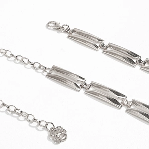 Dettaglio della catena da vita in argento con maglie traforate e ciondolo a rosa