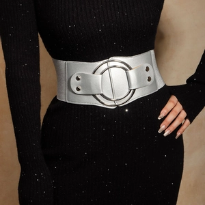 Détail d'une large ceinture élastique argentée avec boucle à double anneau sur robe noire