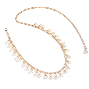 Detailed close-up of golden metal chain belt featuring dangling pearls and lobster clasp