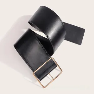 Gros plan d'une large ceinture en cuir noir avec double couture et boucle carrée dorée