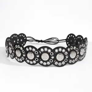 Detail of vintage ethnic belt with embossed metal medallions and silver rivets on black disks