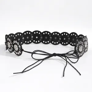 Detail of vintage Y2K waist belt featuring black leather discs and silver metal rivets