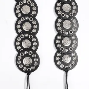 Detail of ethnic style waist belt featuring black leather discs and silver metal eyelets