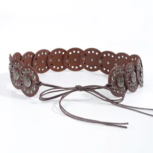Close-up of retro bohemian waist belt with hollow round metal discs and lace-up closure