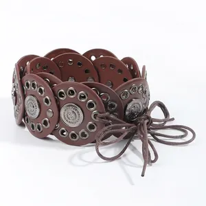 Detailed macro view of vintage waist belt with brown leather circles and carved metal discs