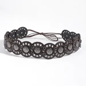Detail of bohemian retro waist belt featuring brown leather discs and embossed metal studs