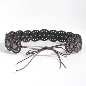 Detailed view of bohemian waist belt featuring vintage metallic discs and woven tie closure