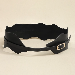 Détail d'une ceinture large en similicuir noir pour femme avec bords ondulés et boucle dorée