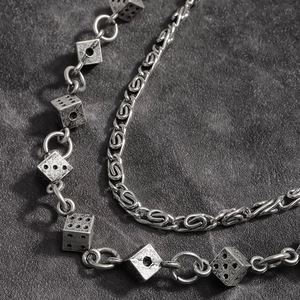 Vue macro d'une chaîne de pantalon punk avec des pendentifs dés en argent vieilli