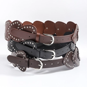 Détail de ceintures en cuir en forme de cœur avec rivets argentés et boucles en métal