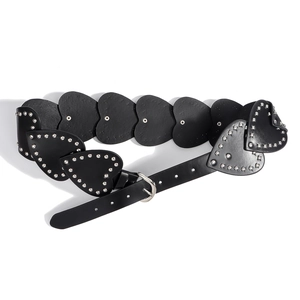 Détail d'une ceinture en cuir noir en forme de cœur avec rivets et boucle argentée