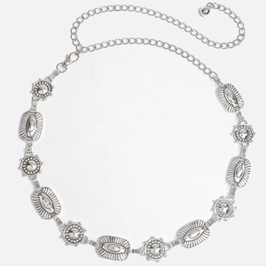 Détail d'une ceinture bohème en métal argenté avec maillons gaufrés et fermoir réglable