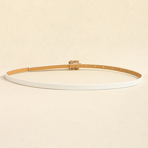 Detail of slim white PU belt with golden rose buckle on warm textured background